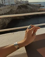 Brazalete rígido de diseño orgánico con textura irregular y acabado artesanal. Pieza abierta ajustable, disponible en bronce o alpaca maciza.