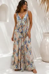 Vestido largo y holgado de tirantes finos, con escote en V pronunciado y cordón ajustable en el pecho con borlas. Presenta un estampado multicolor de efecto marmolado en tonos beige, salmón, azul y verde.