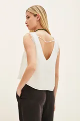 Top negro de poliéster con escote en V, tirantes con detalle de encaje y corte holgado.