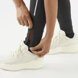 Calzas deportivas negras con bolsillos de almacenamiento y detalles reflectantes en las piernas, de diseño ceñido y elástico.