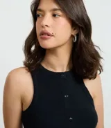 Musculosa de tejido rib color crema, con cuello redondo y cierre frontal con botones. Presenta un diseño ajustado al cuerpo y sin mangas.