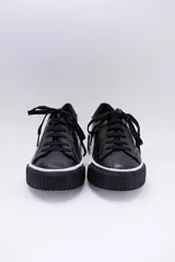 Zapatillas bajas color dorado con diseño trenzado, cordones y suela de goma.