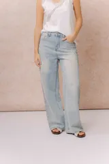 Jean wide leg tiro alto de lavado claro, con diseño de cinco bolsillos, cierre frontal con botón y aplicación de strass en degradé a lo largo de los laterales.