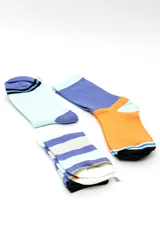 Pack de tres pares de medias estilo crew con diseños geométricos y combinaciones de colores celestes, azules, naranjas y blancos.
