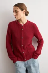 Chaqueta tejida de punto acanalado en color azul marino, con cuello redondo, cierre frontal de botones metálicos y dos bolsillos delanteros aplicados.