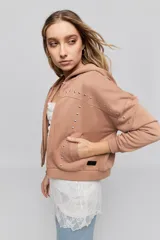 Campera tostada de calce relajado con capucha, cierre frontal, bolsillos laterales y detalles de tachas metálicas.