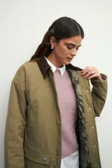 Campera color verde militar con cuello de pana marrón, bolsillos con solapa y botones metálicos. Interior forrado con tela satinada capitoneada.