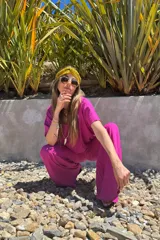 Conjunto fucsia compuesto por un remerón de mangas cortas y un pantalón palazzo de lino.