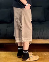 Bermuda de corte baggy color marrón con efecto gastado (lavado vintage), doble carpintero y detalle artesanal visible en el bajo. Incluye un cordón extra confeccionado en la misma tela.