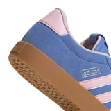 Championes Adidas VL Court 3.0 de estilo urbano, confeccionados en gamuza sintética color azul con las icónicas tres tiras laterales en color rosado. Presentan una suela de goma color caramelo y un diseño inspirado en el calzado retro de canchas.