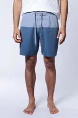 Short de baño bicolor con diseño en tonos celestes y azules, cintura elástica con cordón de ajuste gris y bolsillos laterales.