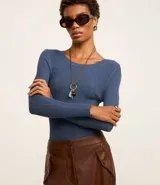 Suéter de punto acanalado color beige, con cuello redondo y mangas largas. Confeccionado en tejido tricot con textura suave y ajuste al cuerpo.