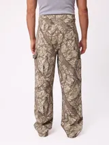 Pantalon recto de lona, color beige, con diseño de paneles reforzados en las piernas y cierre frontal con boton.