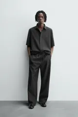 Pantalón de corte relajado confeccionado en tejido fluido con mezcla de lyocell. Presenta cintura elástica ajustable con cordón, bolsillos laterales y un bolsillo trasero de vivo con botón.