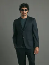 Saco sport de corte clásico, con cuello de solapa, cierre frontal de dos botones y bolsillos de ribete laterales.