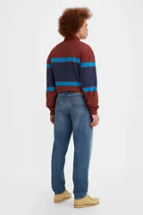 Jean de corte relajado y pierna cónica, con tiro medio y cierre de botones. Presenta un lavado azul medio con efecto desgastado.