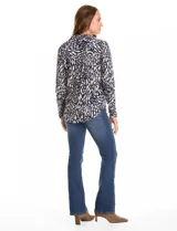 Camisa de manga larga con cuello camisero y cierre frontal de botones. Presenta un estampado abstracto en tonos azul marino y beige.