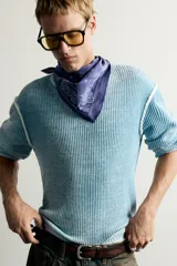 Jersey de punto de corte relaxed fit confeccionado en hilatura de algodón, con cuello redondo y manga larga. Presenta un diseño de efecto lavado con costuras en contraste y acabados en rib.