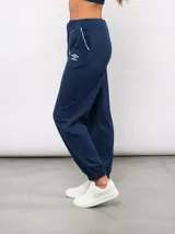 Pantalón de piqué recto color azul marino, con cintura elástica y cordón ajustable. Presenta el escudo del Club Nacional de Football en el muslo izquierdo y el logo de Umbro en el muslo derecho.