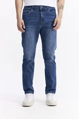 Pantalón de jean con corte slim, de tiro medio, con cierre de botón y cremallera, y bolsillos laterales y traseros.