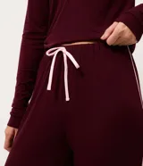 Pantalón de pijama tipo jogger color bordó, confeccionado en viscolycra con cintura elástica y detalles de ribete en contraste en los laterales.