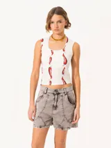 Musculosa blanca con estampado de pimientos rojos, escote redondo con detalle de puntilla y calce al cuerpo.