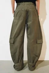 Jeans cargo de tiro medio y corte barrel leg, color verde militar. Presenta bolsillos laterales con solapa en las piernas, bajo ajustable con trabilla y botón, y cierre frontal con cremallera y botón.