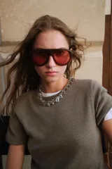 Jersey de punto color rosado claro, con cuello redondo y manga corta. Presenta una textura suave y un acabado ligeramente jaspeado.