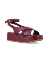 Sandalia plataforma de cuero color bordo, con tiras cruzadas en el empeine y tira ajustable al tobillo con hebilla metálica dorada.