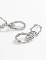 Par de caravanas largas plateadas con eslabones irregulares.