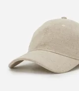 Gorra estilo dad hat de color beige, confeccionada en sarga de algodón y yute. Posee visera curva, diseño liso sin estampas y ajuste posterior con hebilla.