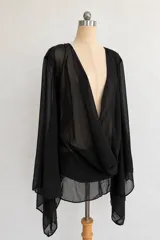 Vestido corto negro de microtul transparente, con escote pronunciado en V y mangas largas amplias tipo campana.