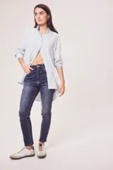 Camisa oversize celeste y blanca a rayas verticales, de mangas largas con puños abotonados y cuello camisero.