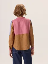Camisa de algodón con diseño de bloques de color en tonos marrón, rosa y lila. Presenta cuello redondo, cierre frontal con botones y mangas largas.
