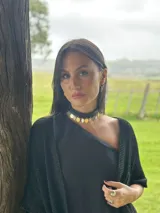 Choker de cuero sintético negro con colgantes de medallitas redondas en tonos dorado y plateado.