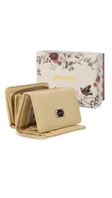 Billetera corta de símil cuero color beige, con cierre a presión y placa metálica decorativa. Cuenta con múltiples compartimentos internos para tarjetas, visor y billetes, además de un compartimento posterior con cierre.