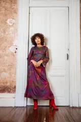 Vestido largo con estampado abstracto en tonos burdeos, verde y gris. Tiene mangas largas acampanadas y escote redondo.