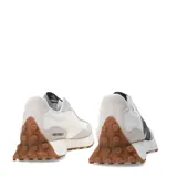 Championes New Balance Life Style modelo 327, con base blanca y paneles de gamuza gris claro. Presenta el logo 'N' sobredimensionado en color negro y suela de goma color caramelo.