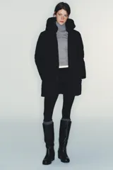 Chaqueta acolchada de color negro, resistente al agua y al viento, con aislamiento térmico. Presenta cuello subido con capucha, cierre frontal con cremallera termosellada de doble cursor, bolsillos laterales con forro polar y puños interiores elásticos.