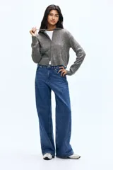 Saco corto de punto trenzado con cierre frontal bidireccional y capucha con cordón ajustable. Presenta puños y bajo en punto acanalado.