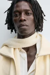 Sudadera color crema de algodón con interior afelpado, corte relajado, cuello subido y manga larga. Presenta bolsillos de vivo en la cadera y acabados en rib, con cierre frontal de cremallera.