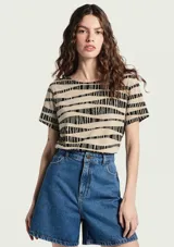Blusa de manga corta color beige con estampado de líneas negras horizontales y abstractas, escote redondo y corte clásico.