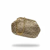 Bolso de mano tipo clutch, confeccionado artesanalmente mediante una técnica de anudado con fibras textiles recicladas en color champagne. Presenta una estructura redondeada y cuenta con una cadena dorada desmontable para llevar al hombro o como bolso de mano. El interior se encuentra forrado en seda.