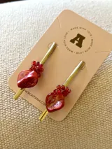 Par de caravanas con forma de gota, con cuentas rojas y canutillos dorados.