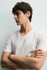 Camiseta blanca de algodón con elasticidad, corte slim fit, cuello en V y mangas cortas.