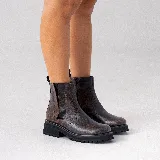 Bota corta de cuero vacuno con acabado desgastado en tonos oscuros, diseño tipo chelsea con elástico lateral externo y cierre interno. Cuenta con suela de goma tipo track con plataforma.