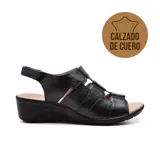 Sandalia de cuero negra con diseño de tiras anchas en el empeine, ajuste con velcro en el tobillo y plataforma baja.