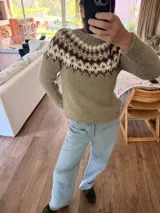 Sweater tejido a mano de corte clásico, color gris con diseño de guarda nórdica en el canesú en tonos blanco, marrón y detalles en rojo.