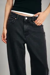 Jean de tiro alto con corte wide leg, confeccionado en denim de algodón con leve elasticidad. Presenta diseño clásico de cinco bolsillos, cierre frontal con botón y pernera amplia.