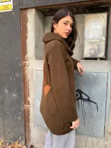 Saco marrón de lana Merino con cuello alto y cierre con broches tipo toggle.